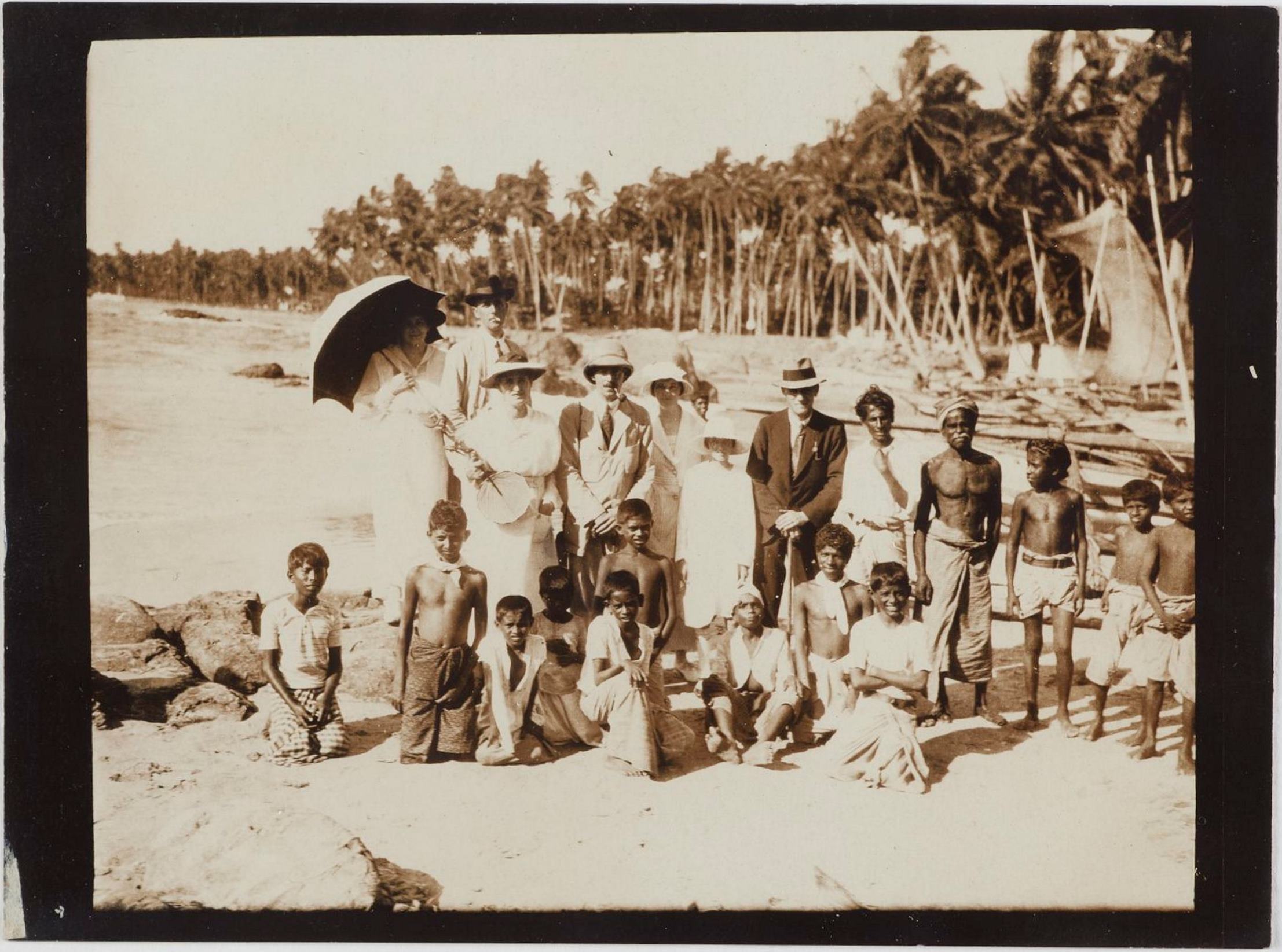 Travellers from the Osterley (including Leslie and Dora Walford) with Sinhalese locals at Mount Lavinia beach, Colombo, Ceylon (Sri Lanka), 6 April 1919 / photographer unknown